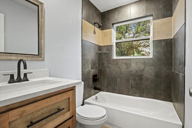 full bathroom featuring tiled shower / bath, vanity, and toilet