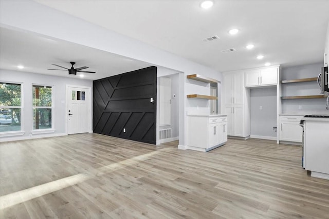 kitchen with ceiling fan, light wood-type flooring, and white cabinets