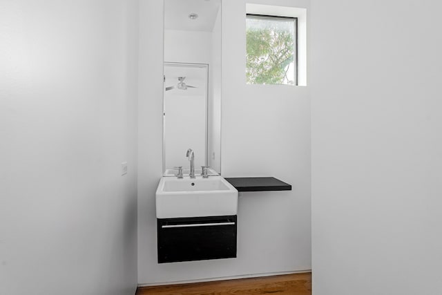 bathroom with hardwood / wood-style floors, ceiling fan, and sink