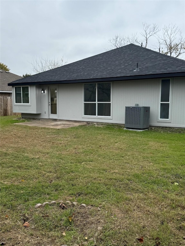 back of property with a patio area, a yard, and central AC