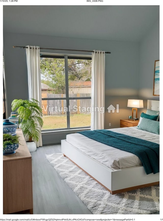 bedroom with hardwood / wood-style floors and multiple windows