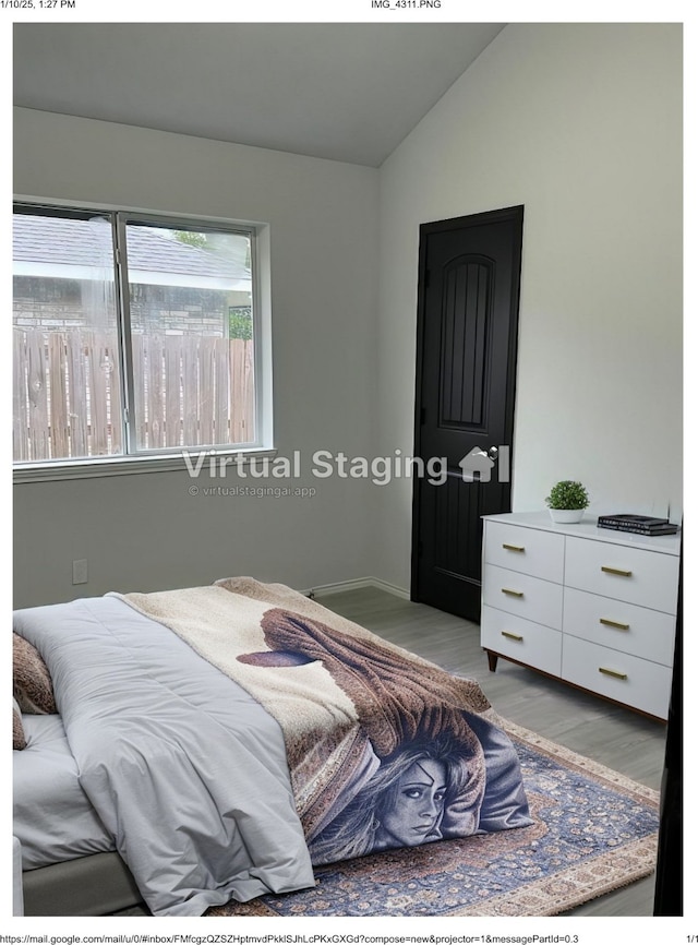 bedroom with light hardwood / wood-style floors and vaulted ceiling