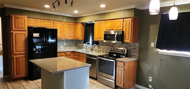 kitchen with crown molding, hanging light fixtures, tasteful backsplash, a kitchen island, and stainless steel appliances