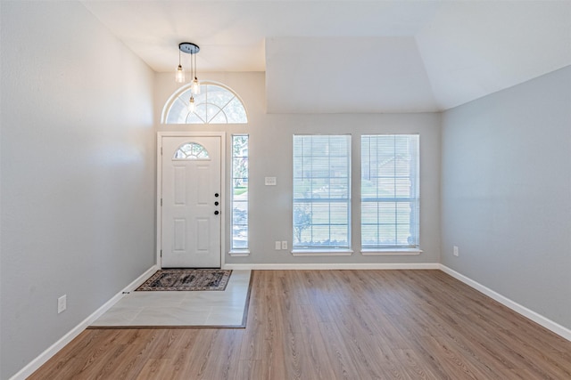 foyer entrance with light wood-type flooring and lofted ceiling