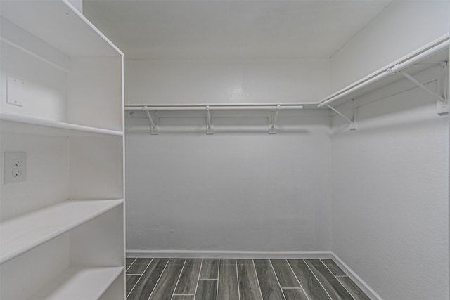 walk in closet with dark hardwood / wood-style floors