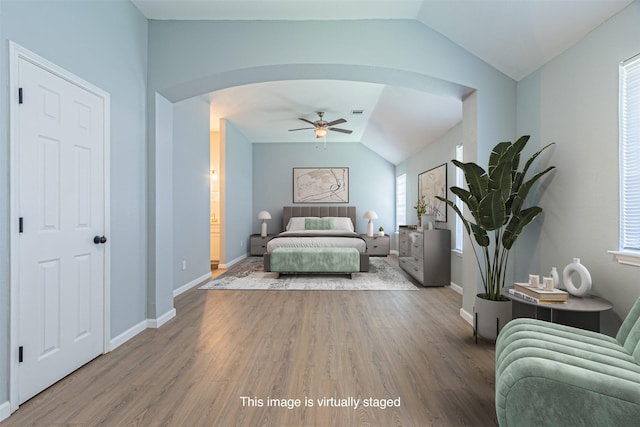 bedroom featuring ensuite bath, ceiling fan, lofted ceiling, and hardwood / wood-style flooring