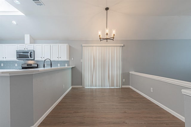 kitchen featuring white cabinets, appliances with stainless steel finishes, tasteful backsplash, and dark hardwood / wood-style floors