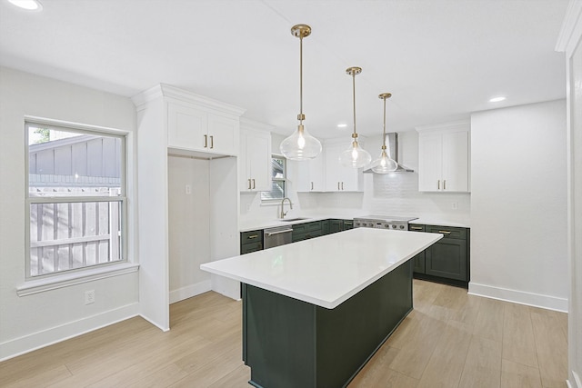 kitchen with white cabinetry, a center island, light hardwood / wood-style floors, and decorative light fixtures