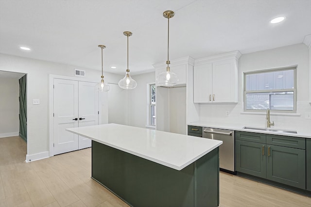 kitchen featuring stainless steel dishwasher, sink, light hardwood / wood-style flooring, white cabinetry, and hanging light fixtures