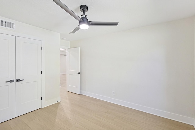 unfurnished bedroom featuring ceiling fan, a closet, and light hardwood / wood-style flooring