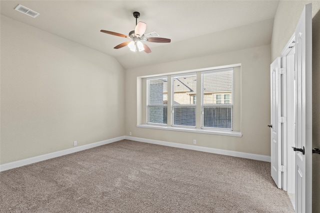 spare room featuring ceiling fan, light colored carpet, and lofted ceiling