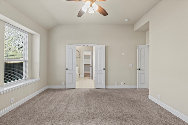 unfurnished bedroom with light carpet, vaulted ceiling, and ceiling fan