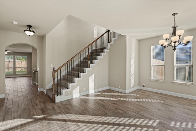 foyer with hardwood / wood-style floors and ceiling fan with notable chandelier