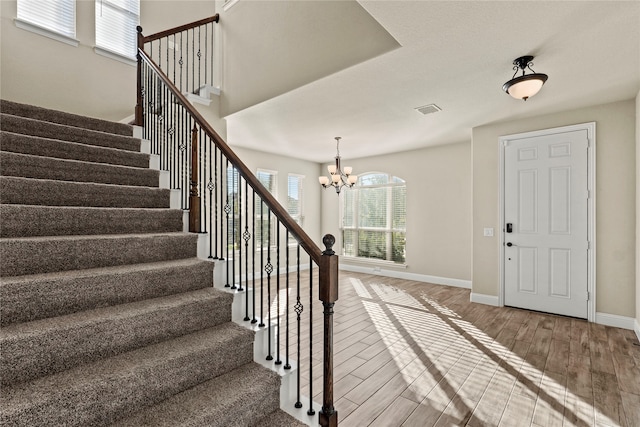 entrance foyer with wood-type flooring and an inviting chandelier