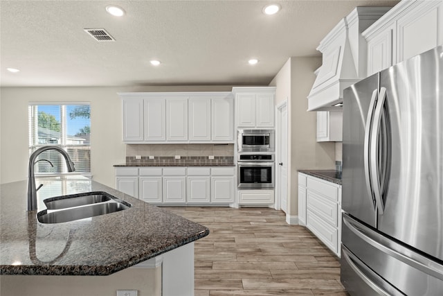 kitchen featuring white cabinets, sink, appliances with stainless steel finishes, and dark stone counters