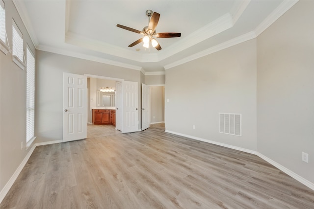 unfurnished bedroom featuring multiple windows, ceiling fan, crown molding, and ensuite bath