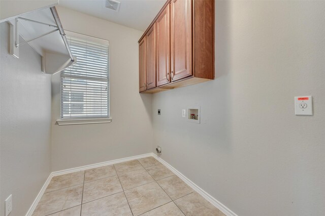 washroom with hookup for a washing machine, light tile patterned flooring, cabinets, and hookup for an electric dryer