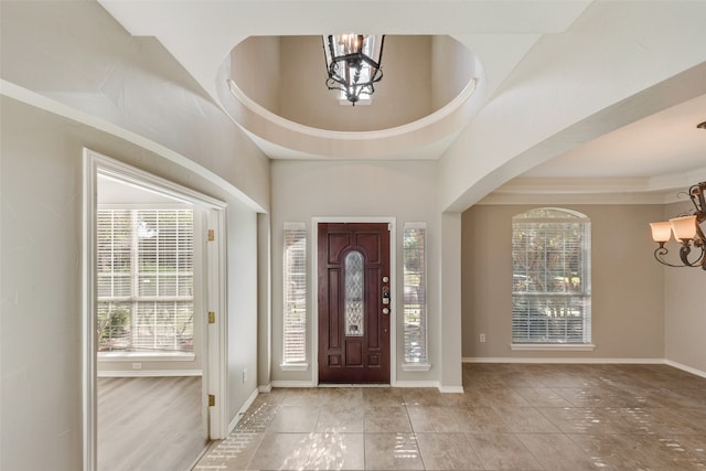 foyer featuring a towering ceiling and a chandelier