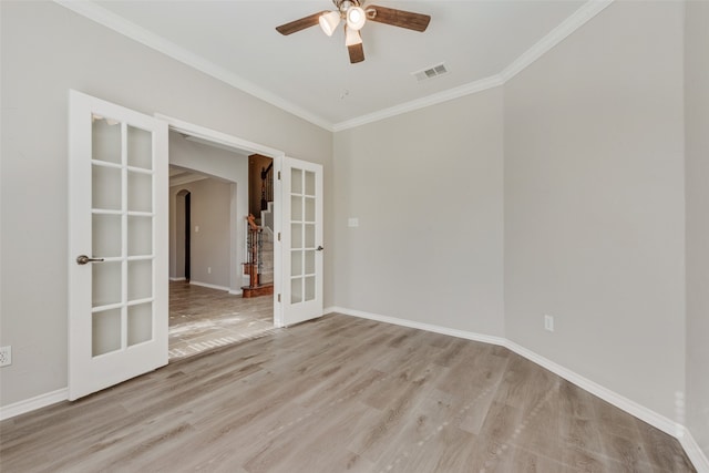 empty room with light wood-type flooring, ornamental molding, and french doors