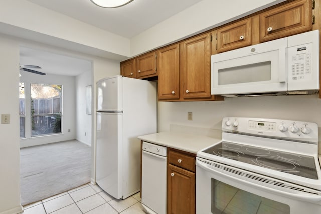 kitchen with light tile patterned floors, white appliances, and ceiling fan