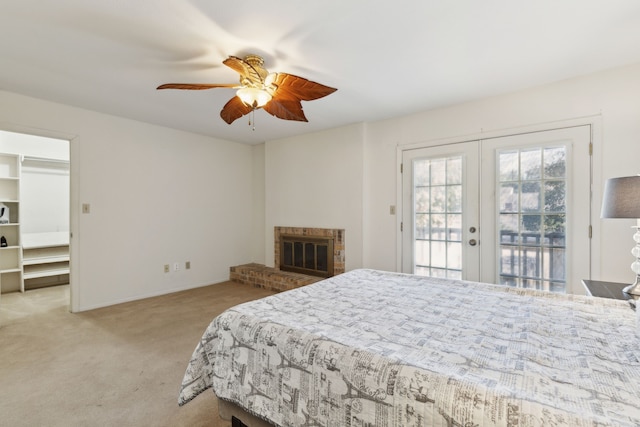 bedroom featuring french doors, access to outside, light colored carpet, ceiling fan, and a fireplace