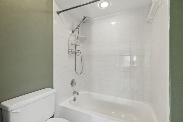 bathroom featuring toilet and tiled shower / bath