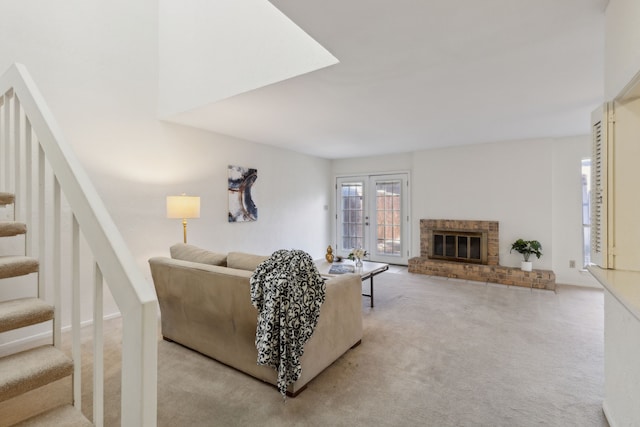 carpeted living room featuring a brick fireplace and french doors