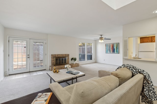 living room featuring a wealth of natural light, french doors, ceiling fan, and light colored carpet