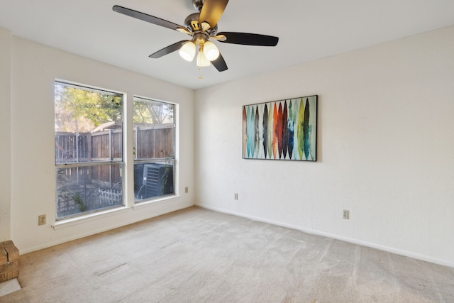 carpeted spare room featuring ceiling fan