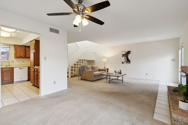 unfurnished living room featuring light carpet, ceiling fan, and sink