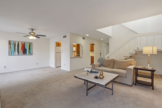 carpeted living room with ceiling fan