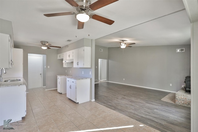 kitchen featuring white cabinetry, sink, light stone countertops, and light hardwood / wood-style flooring