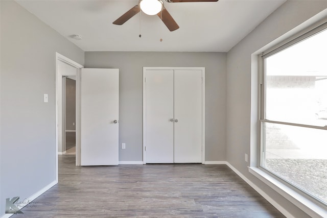 unfurnished bedroom with ceiling fan, a closet, and light hardwood / wood-style floors