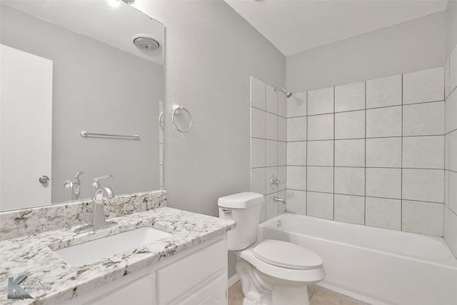 full bathroom with tiled shower / bath, tile patterned flooring, vanity, and toilet