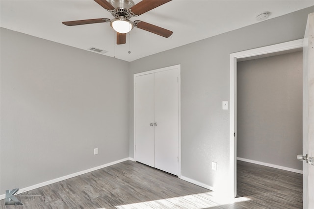 unfurnished bedroom featuring hardwood / wood-style flooring, ceiling fan, and a closet