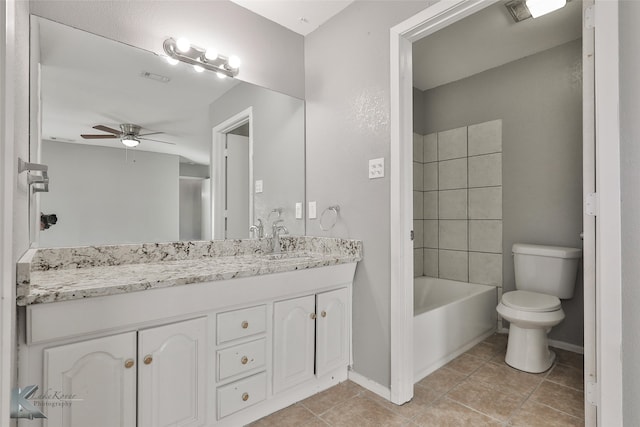 full bathroom featuring vanity, tiled shower / bath combo, ceiling fan, tile patterned flooring, and toilet