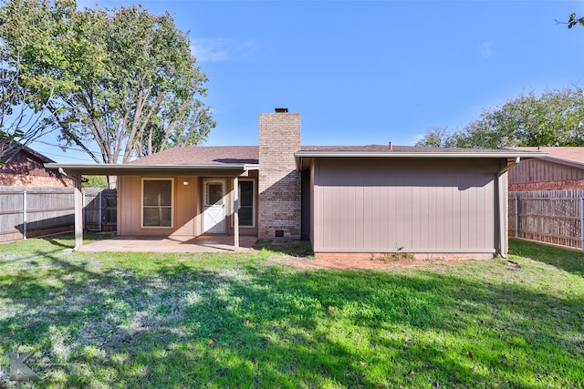 back of property with a yard and a patio area