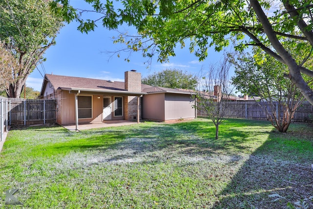 rear view of property featuring a lawn and a patio area