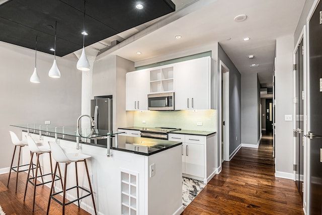 kitchen featuring pendant lighting, backsplash, white cabinets, dark hardwood / wood-style flooring, and stainless steel appliances