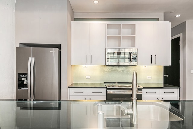 kitchen with white cabinets, backsplash, and stainless steel appliances