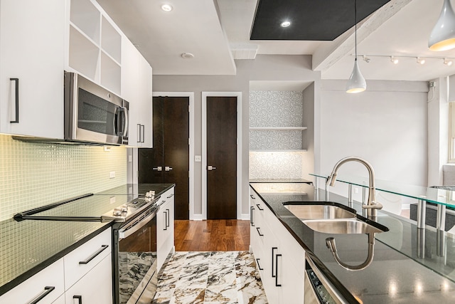 kitchen with sink, hanging light fixtures, tasteful backsplash, white cabinetry, and stainless steel appliances