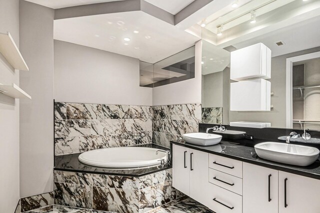 bathroom with vanity and a relaxing tiled tub