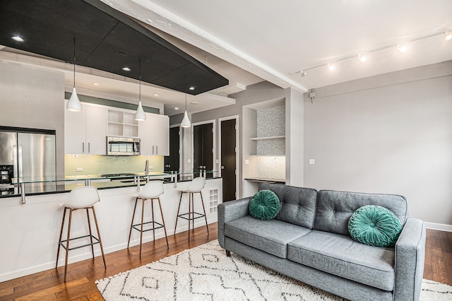 living room with wood-type flooring and track lighting