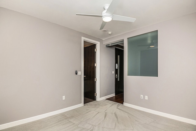 carpeted empty room featuring ceiling fan