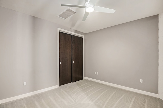 unfurnished bedroom with carpet, a closet, and ceiling fan