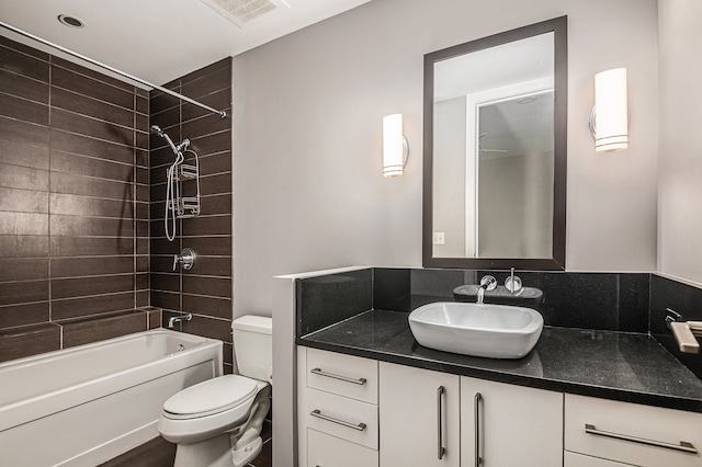 full bathroom with tiled shower / bath combo, toilet, backsplash, and vanity