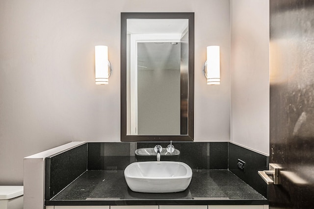 bathroom featuring vanity, tasteful backsplash, and toilet