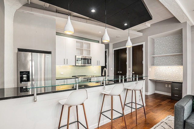 kitchen featuring pendant lighting, dark hardwood / wood-style floors, white cabinetry, and appliances with stainless steel finishes