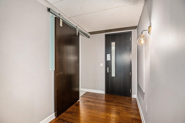 entrance foyer with a barn door and dark hardwood / wood-style floors