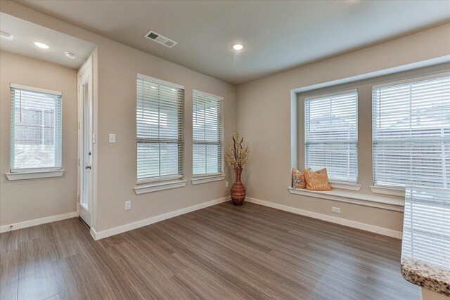 kitchen with sink, stainless steel appliances, hanging light fixtures, dark hardwood / wood-style floors, and a center island with sink